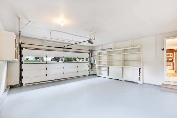 Non-insulated garage door with windows showing interior track and hardware — garage door repair service